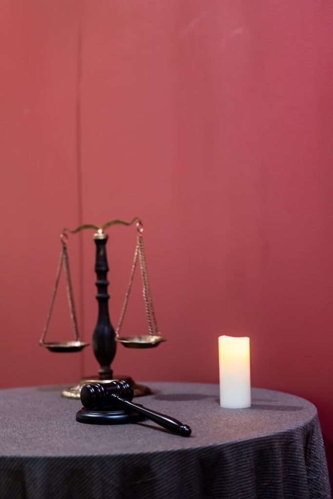pexels photo 34611943 A symbolic display of justice featuring a gavel, scales, and candle on a table.