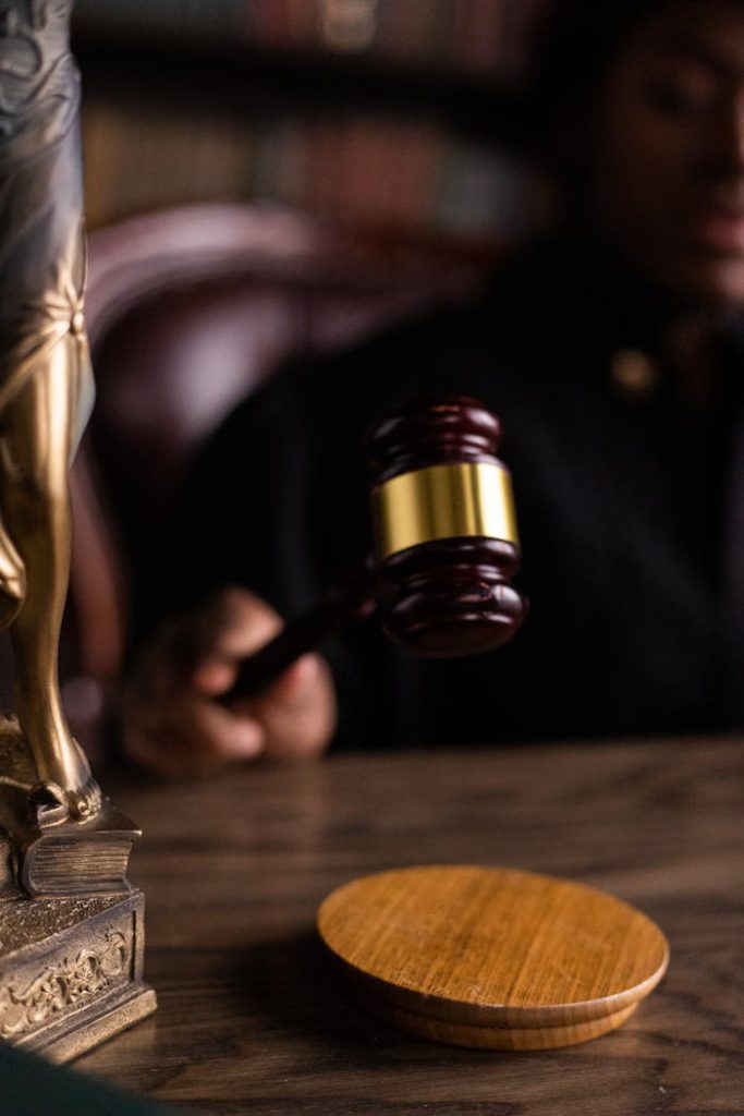 pexels photo 6077422 Close-up of a judge holding a gavel, symbolizing justice and law in a courtroom setting.