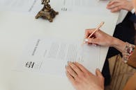 pexels photo 7876053 7876053 Close-up of hands signing a divorce decree document on a desk, showcasing legal process.