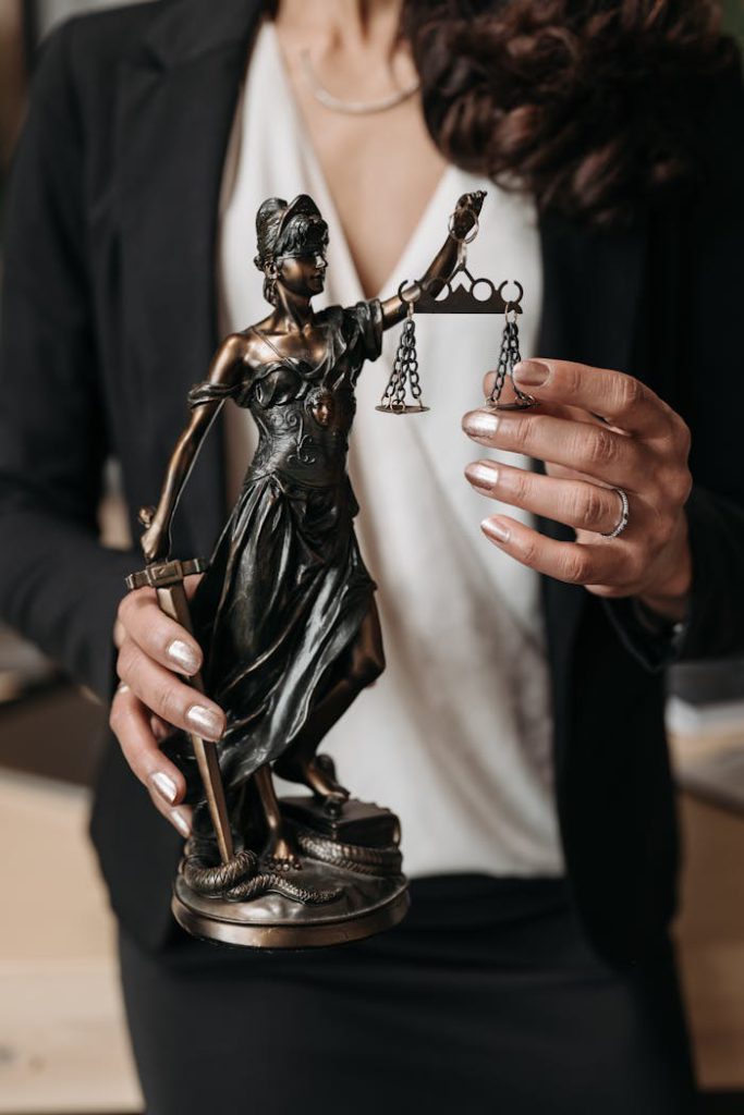 pexels photo 8111818 Close-up of Lady Justice statuette held by a lawyer, symbolizing law and justice.